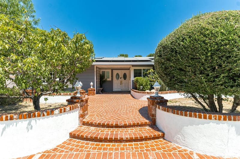 Red brick entryway with nice landscaping.