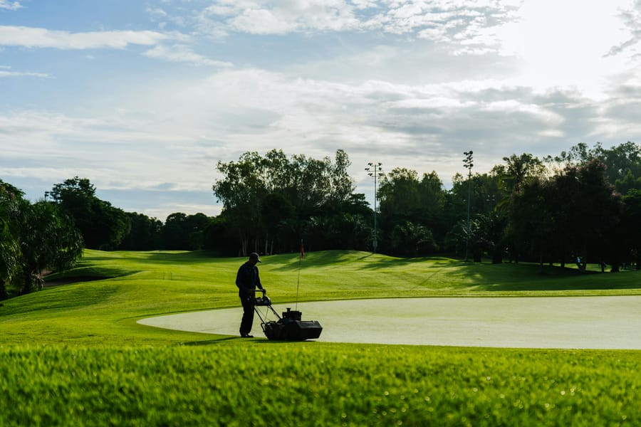 Man mowing beautiful golf course.