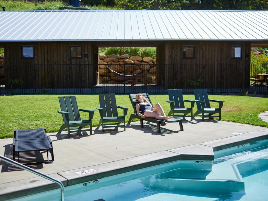 Woman relaxing in a backyard by the pool.