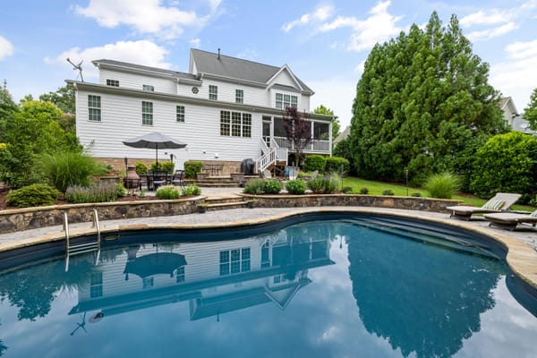 Poolside patio with landscaping and seating area.