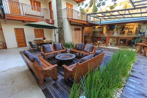 Outdoor lounge area with fireplace and wood seating.